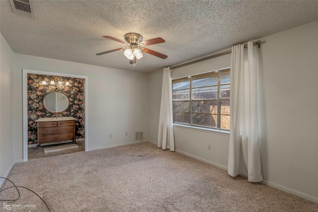 empty room featuring visible vents, carpet flooring, baseboards, and a ceiling fan