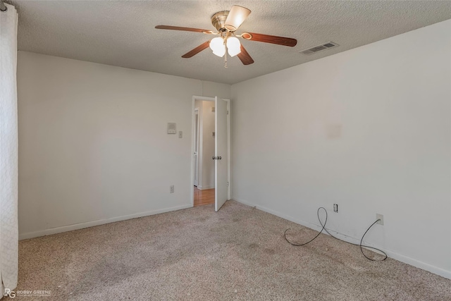 empty room with visible vents, baseboards, carpet, a textured ceiling, and a ceiling fan