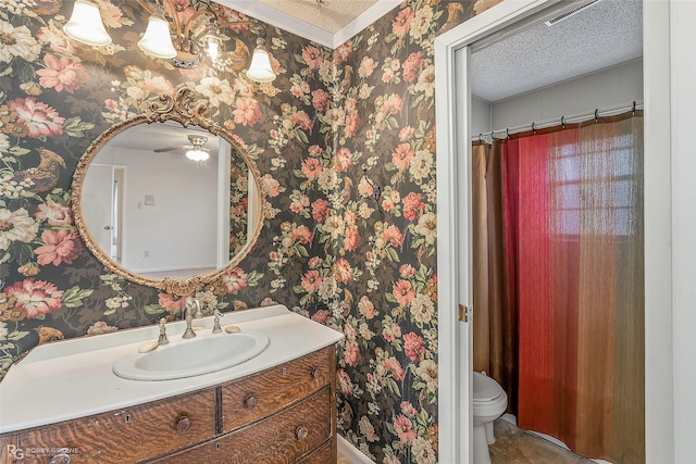 bathroom with wallpapered walls, vanity, and a textured ceiling