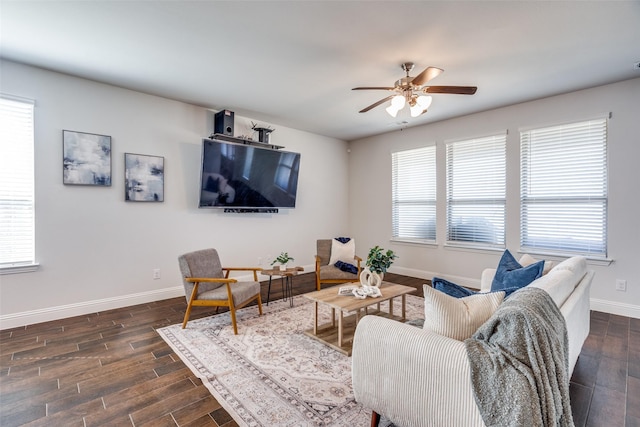 living area with dark wood-type flooring, a ceiling fan, and baseboards