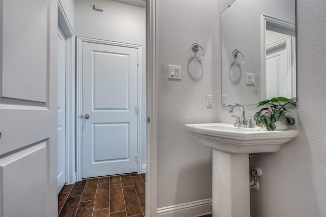 bathroom featuring a textured wall and wood tiled floor