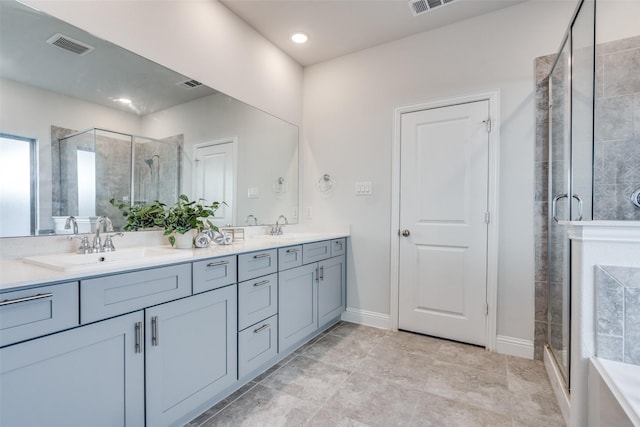 bathroom featuring visible vents, a shower stall, a sink, and double vanity