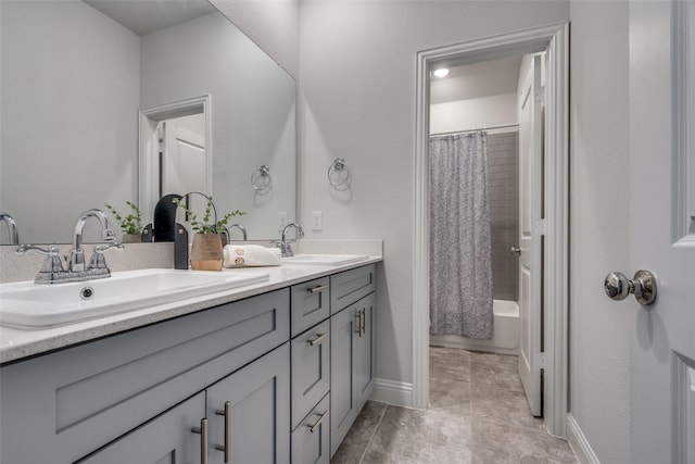 full bath featuring a sink, baseboards, shower / tub combo with curtain, and double vanity