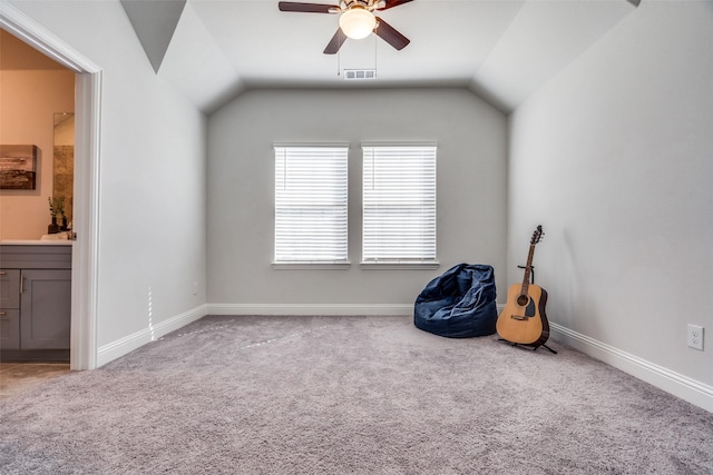 living area with visible vents, carpet, ceiling fan, and vaulted ceiling