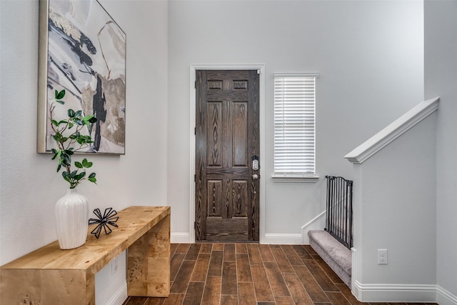 entrance foyer with dark wood finished floors, stairway, and baseboards