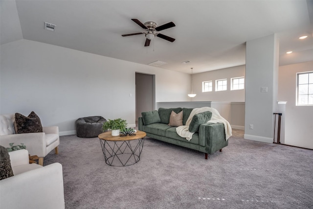 carpeted living area with visible vents, baseboards, ceiling fan, and vaulted ceiling