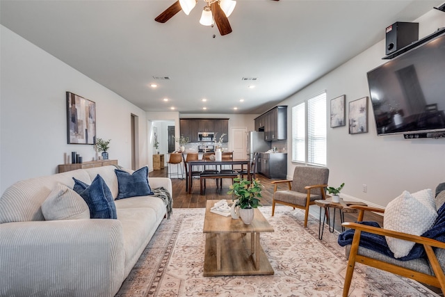 living room featuring visible vents, light wood-style flooring, recessed lighting, baseboards, and ceiling fan