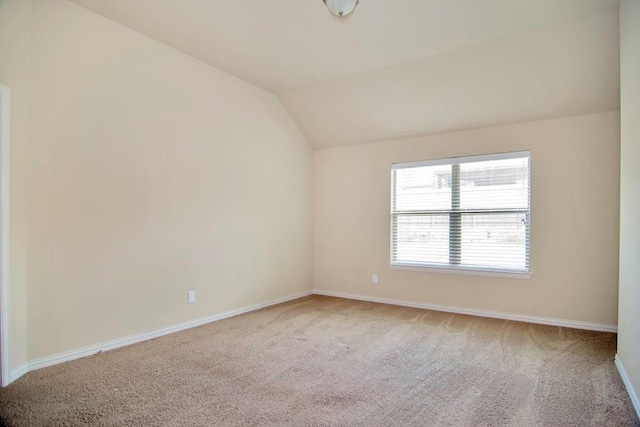 carpeted empty room with lofted ceiling and baseboards