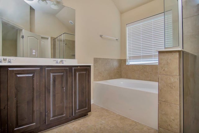 bathroom featuring a garden tub, double vanity, a stall shower, tile patterned floors, and a sink