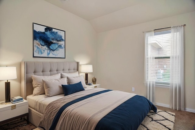 bedroom featuring baseboards, lofted ceiling, and carpet