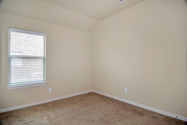 carpeted empty room with baseboards and lofted ceiling