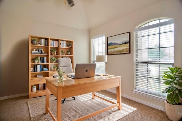 office space with light carpet, baseboards, and vaulted ceiling