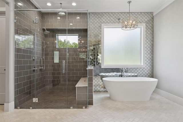 bathroom featuring baseboards, a freestanding tub, recessed lighting, a shower stall, and a chandelier