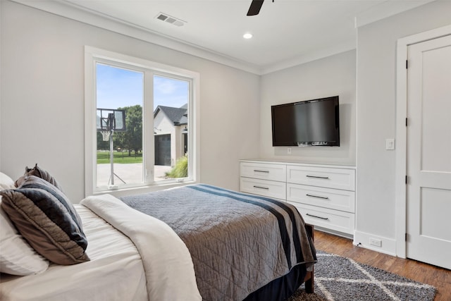 bedroom with visible vents, ornamental molding, wood finished floors, recessed lighting, and baseboards