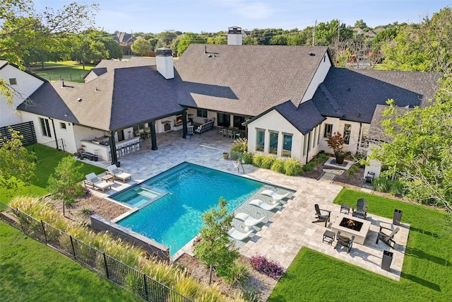 view of swimming pool featuring outdoor dry bar, a patio, a fenced backyard, an outdoor fire pit, and a yard