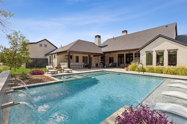 view of pool featuring a patio area, fence, a pool with connected hot tub, and an outdoor hangout area