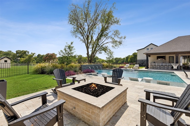 view of patio / terrace featuring outdoor dry bar, a fenced in pool, an outdoor fire pit, and fence