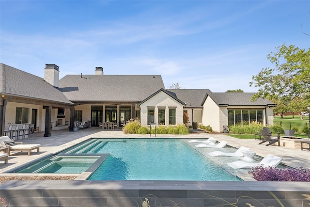 view of swimming pool featuring a patio, a fire pit, and a pool with connected hot tub