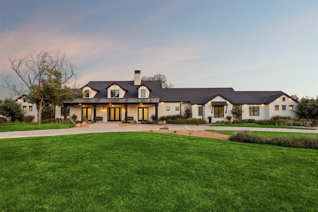 modern farmhouse style home with a lawn, metal roof, and a standing seam roof