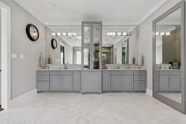 full bathroom with crown molding, two vanities, baseboards, and a sink