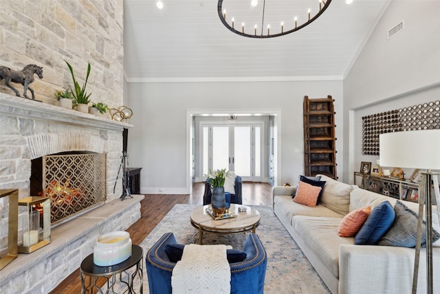 living room featuring visible vents, ornamental molding, an inviting chandelier, wood finished floors, and high vaulted ceiling