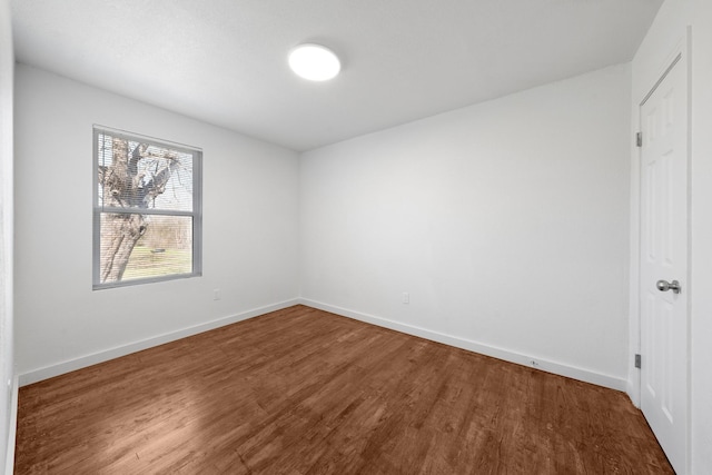 spare room with wood finished floors and baseboards