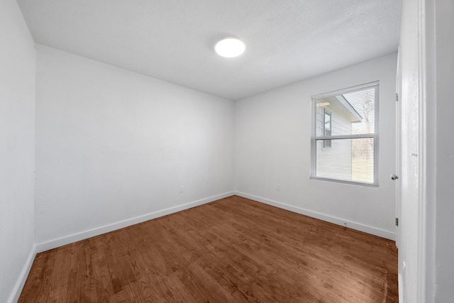 unfurnished room with wood finished floors and baseboards