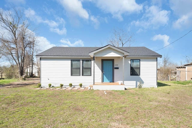 bungalow-style home with a front yard and roof with shingles