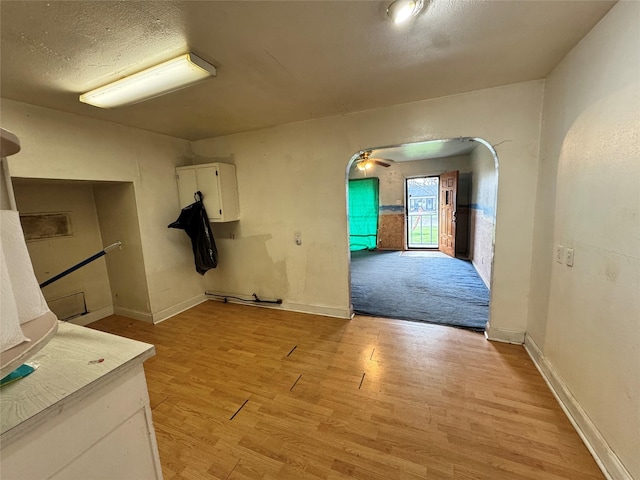 interior space with light wood-style floors, baseboards, and a textured ceiling