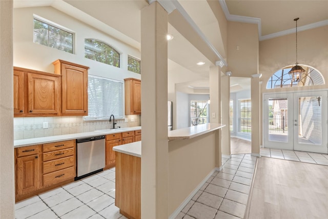 kitchen with ornamental molding, decorative backsplash, light countertops, a sink, and stainless steel dishwasher