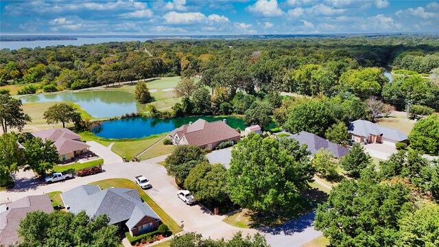 drone / aerial view featuring a forest view, a water view, and a residential view