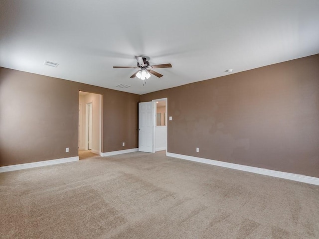 unfurnished room with visible vents, a ceiling fan, baseboards, and light carpet