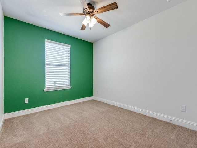 spare room featuring carpet flooring, baseboards, and a ceiling fan