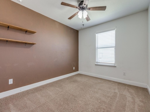 carpeted empty room featuring baseboards and ceiling fan