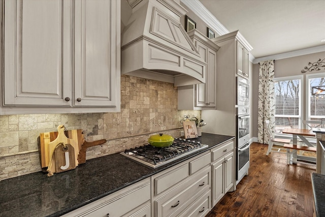 kitchen with premium range hood, tasteful backsplash, appliances with stainless steel finishes, crown molding, and dark wood-style flooring