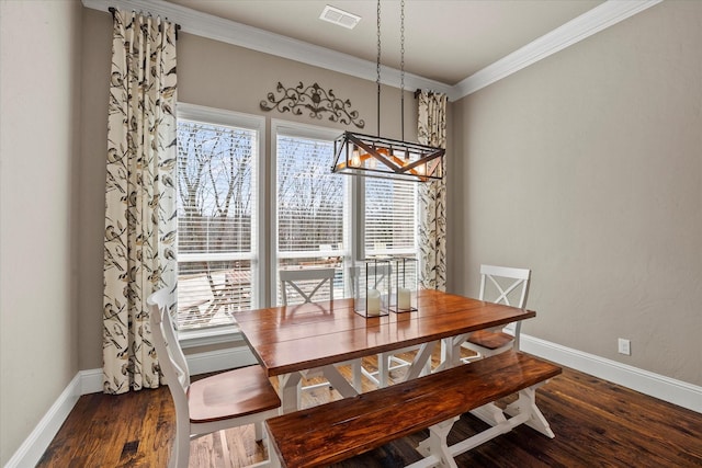 dining area featuring visible vents, ornamental molding, baseboards, and wood finished floors