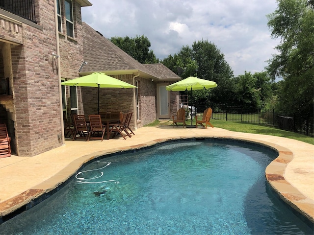 view of swimming pool with a patio, a fenced in pool, and fence