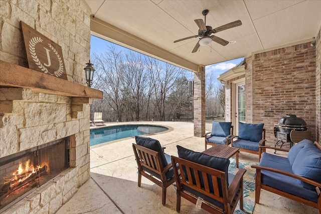 view of patio featuring a grill, a ceiling fan, and an outdoor living space with a fireplace