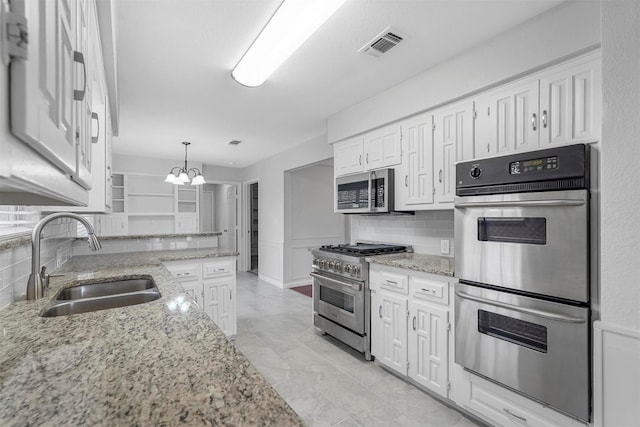 kitchen featuring visible vents, a sink, white cabinetry, stainless steel appliances, and an inviting chandelier