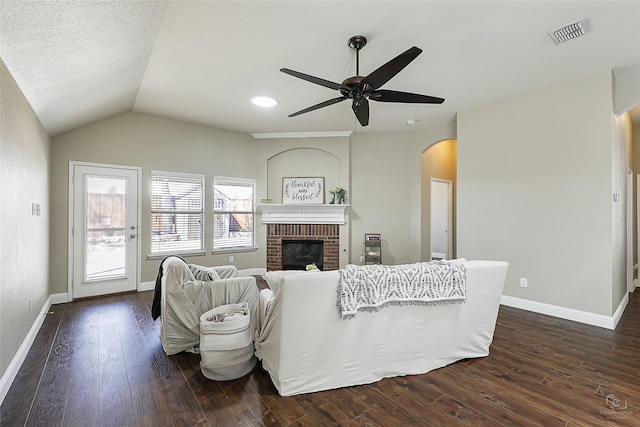 living area with visible vents, a ceiling fan, arched walkways, lofted ceiling, and dark wood-style flooring