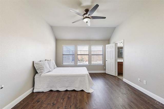 bedroom with baseboards, vaulted ceiling, ensuite bath, a ceiling fan, and dark wood-style flooring