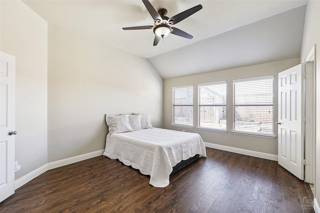 bedroom with baseboards, dark wood-type flooring, ceiling fan, and vaulted ceiling