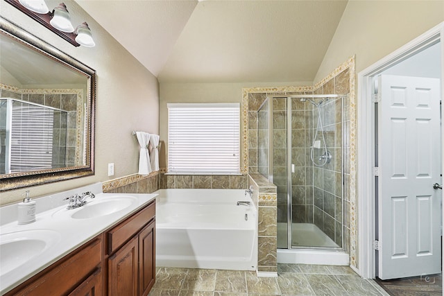 bathroom with a bath, a stall shower, lofted ceiling, and a sink