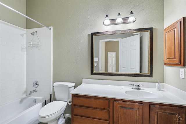 bathroom featuring toilet, vanity, shower / bath combination, and a textured wall