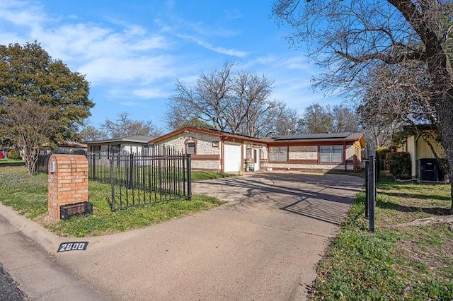 view of front facade with solar panels, a front lawn, fence, a garage, and driveway