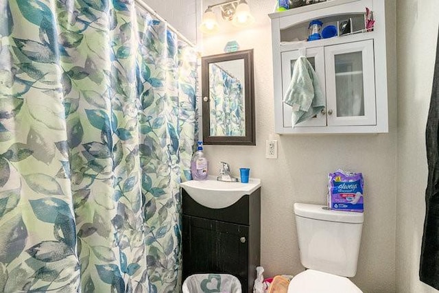 bathroom with toilet, vanity, and a shower with shower curtain