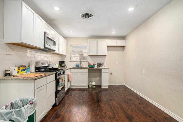 kitchen featuring white cabinets, dark wood-style flooring, appliances with stainless steel finishes, and a sink