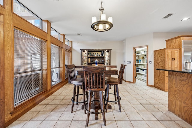 dining room featuring light tile patterned floors, visible vents, baseboards, and an inviting chandelier