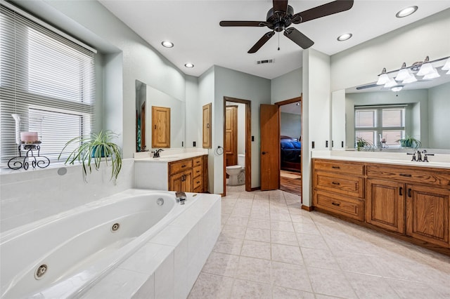 ensuite bathroom featuring visible vents, toilet, a tub with jets, vanity, and a ceiling fan