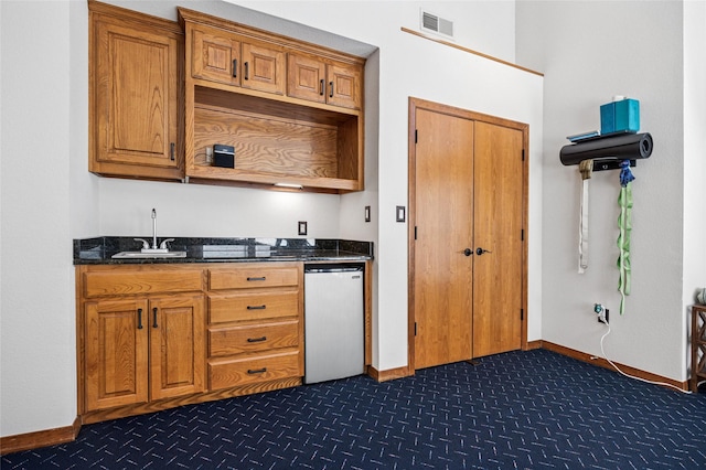 kitchen featuring visible vents, open shelves, a sink, fridge, and brown cabinetry